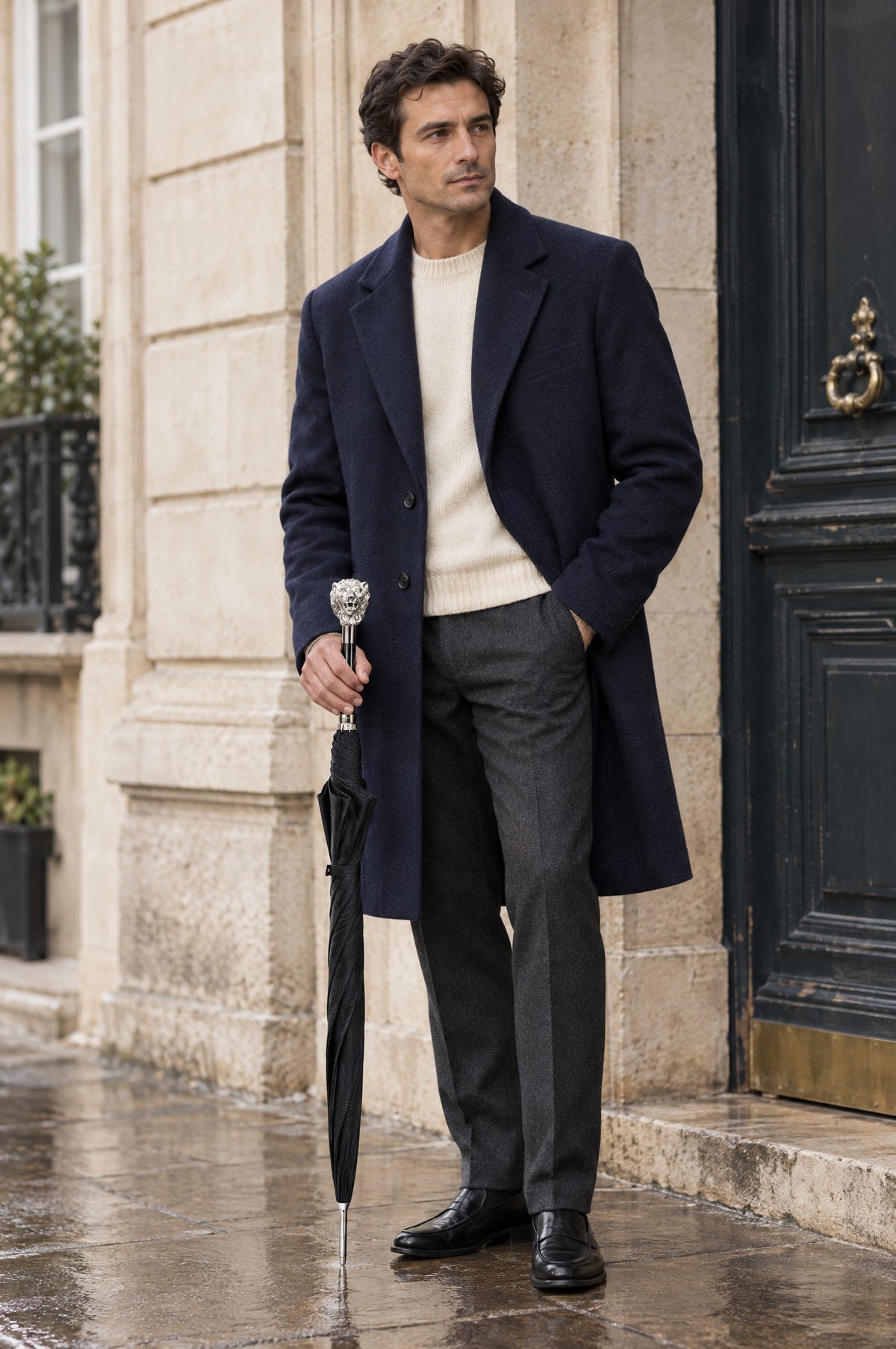A man with a Pasotti umbrella and tailored outerwear outdoors.