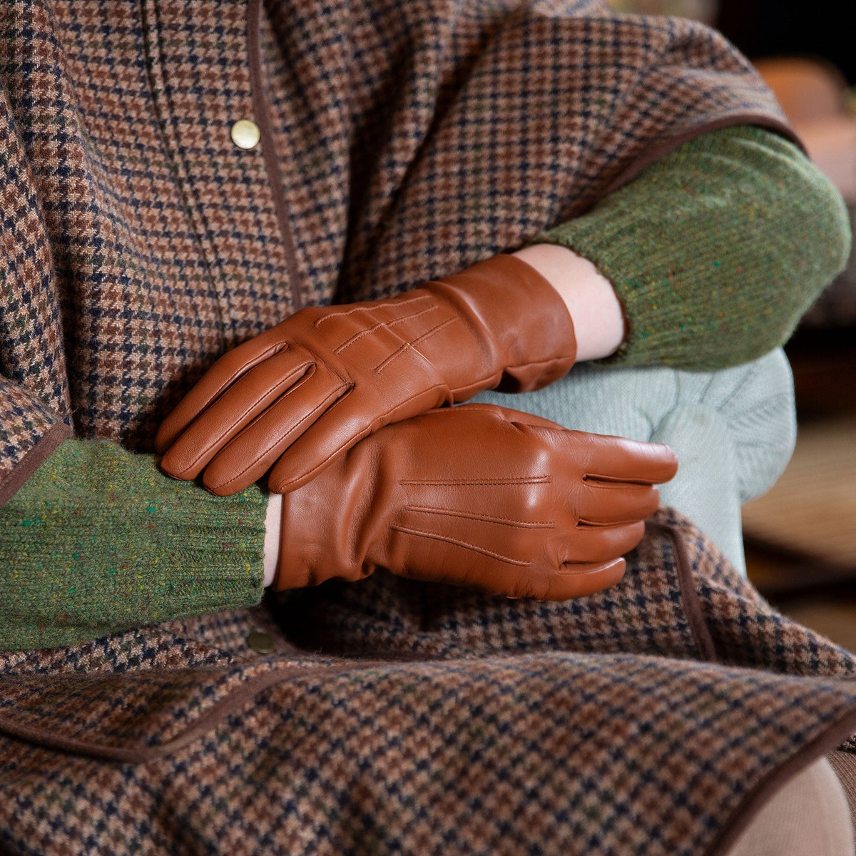 Woman wearing cashmere-lined leather gloves in cognac